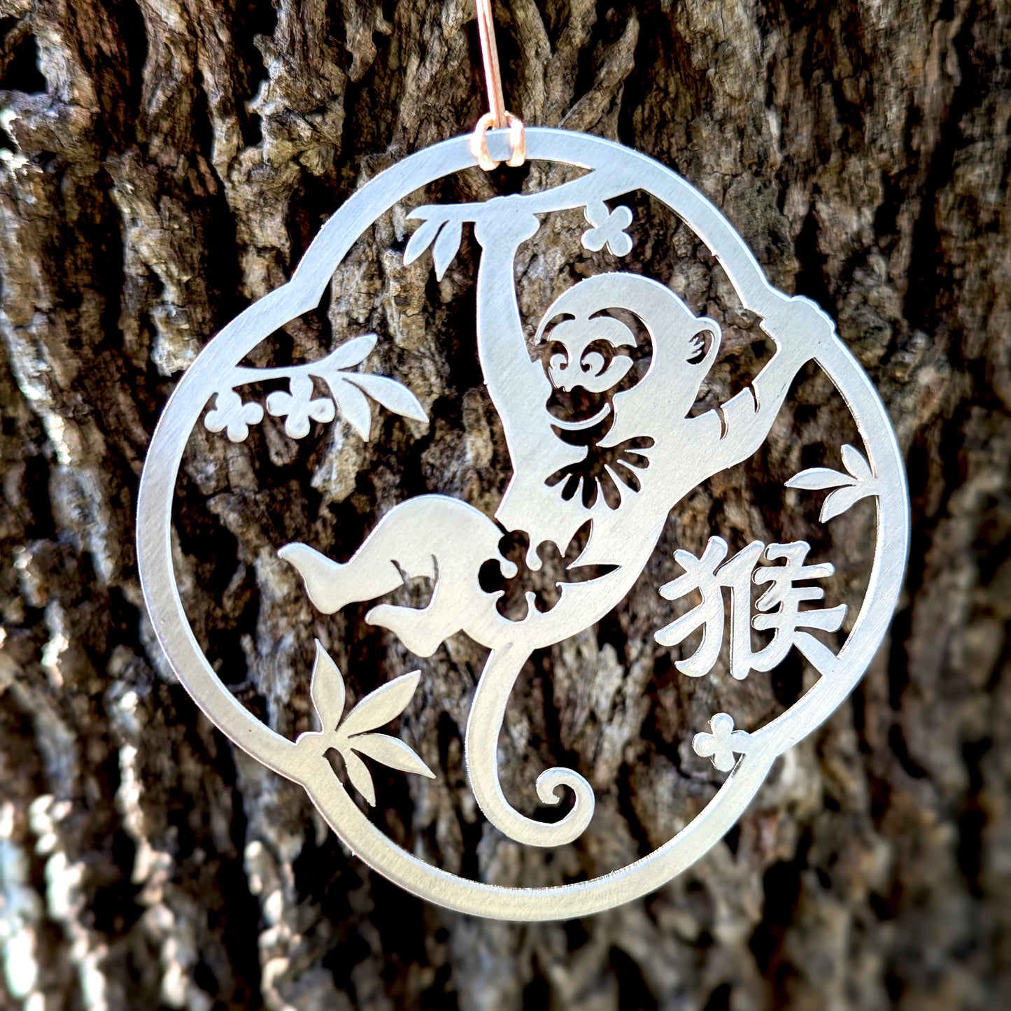 a metal ornament hanging from a tree