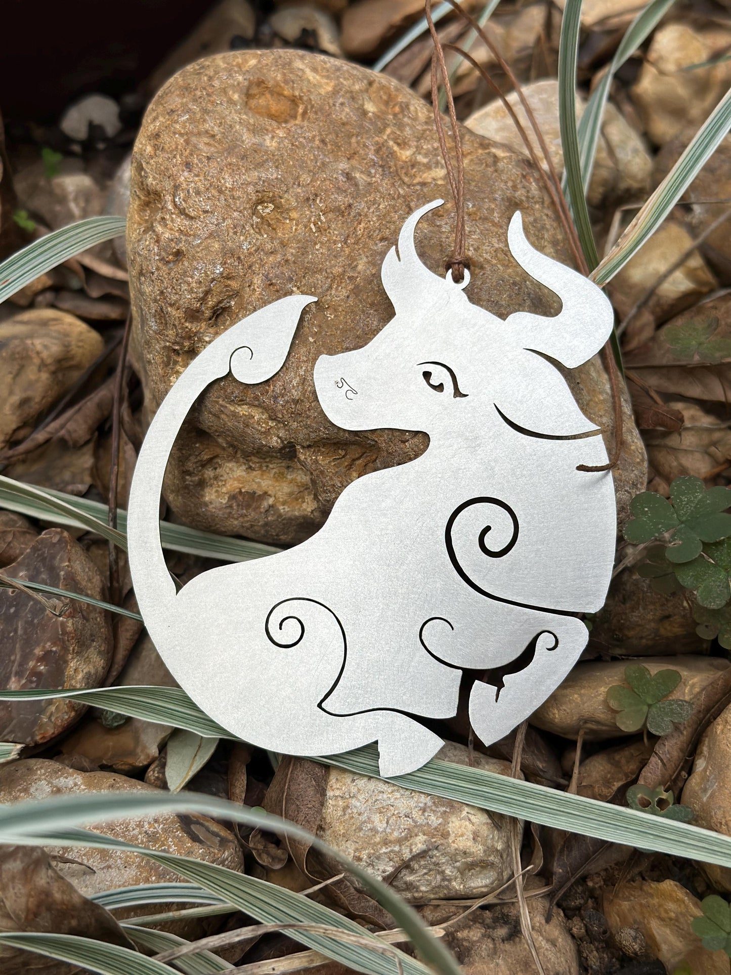 a metal cutout of an elephant on a rock