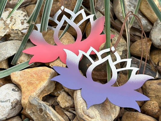 Lotus ornaments in pink and purple laid down on rocks