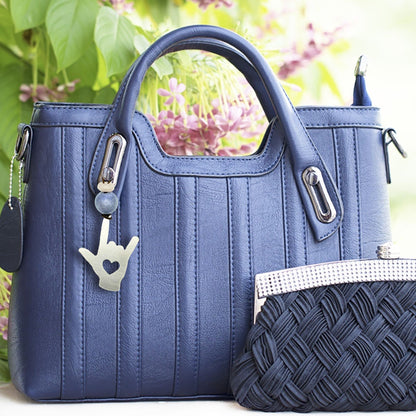 a blue purse sitting next to a purse on a table