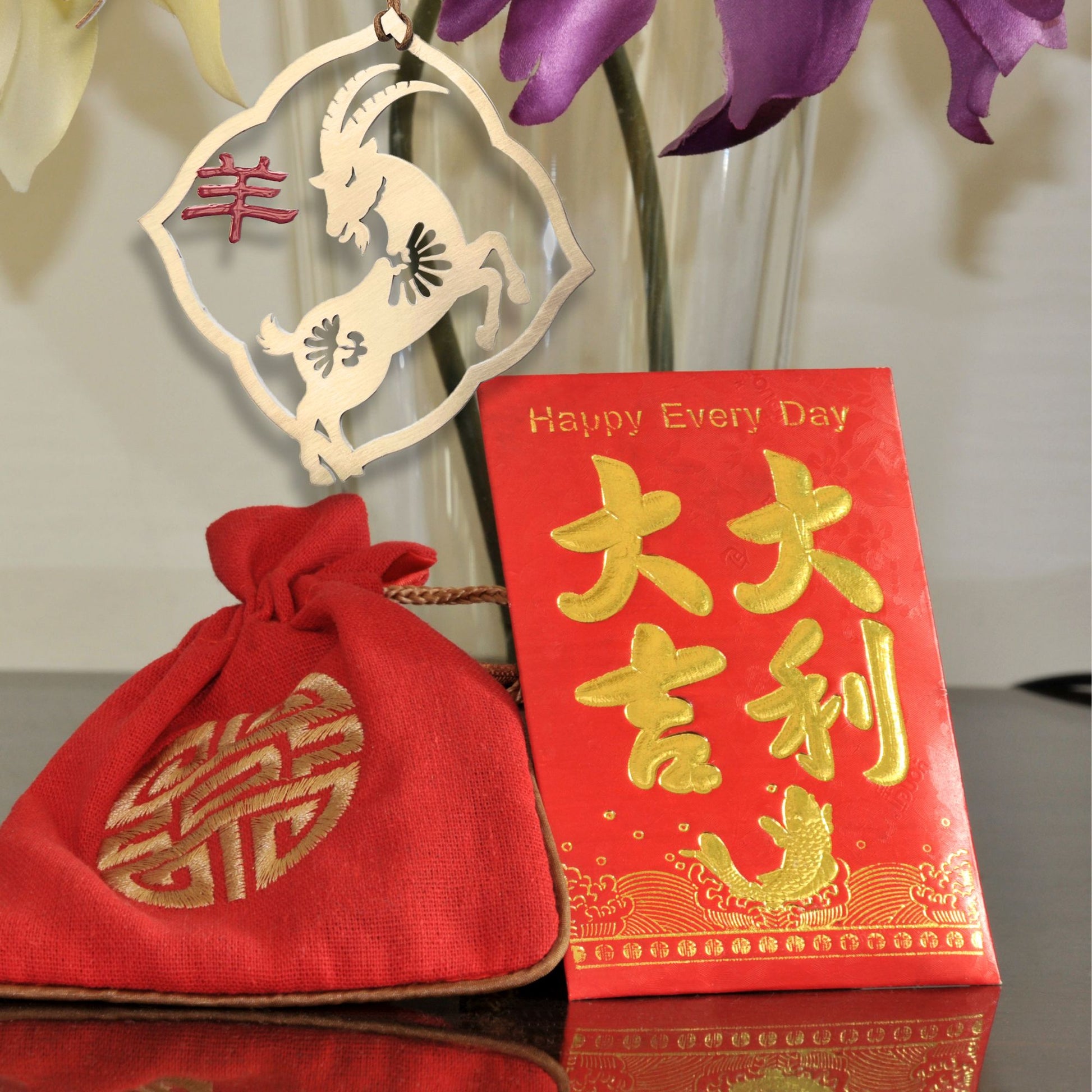 a vase filled with purple flowers next to a red bag