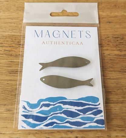 sardine magnets made of stainless steel and placed on an illustrated card and in a plastic pouch