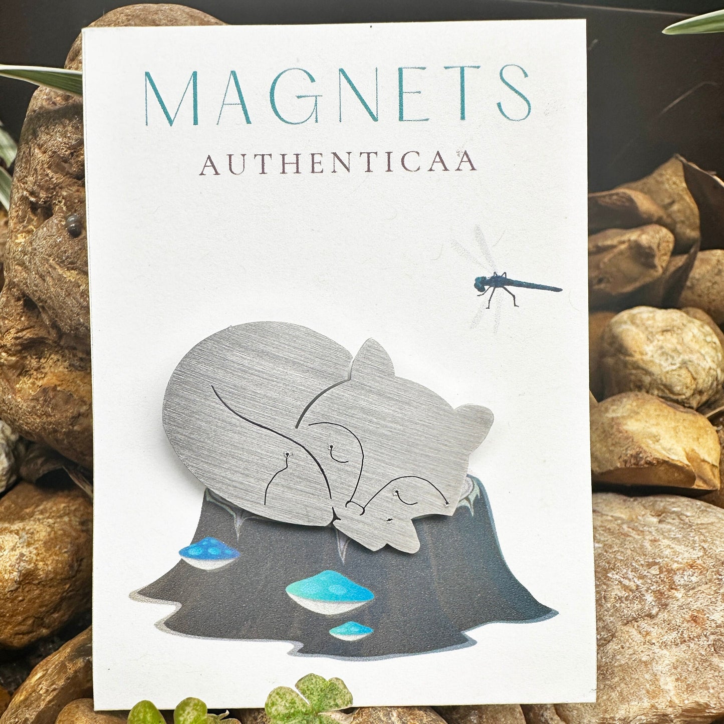fox sleeping magnet made of stainless steel, placed on an illustrated card