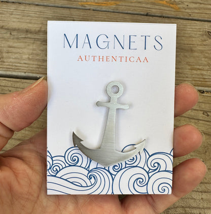 Anchor magnet made of stainless steel placed on an illustrated eco friendly card. Held in hand