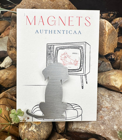 Stainless steel dog  sitting his back to us, watching TV on the illustrated card